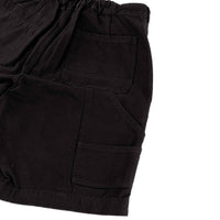 Close-up of black shorts with two front pockets on a white background